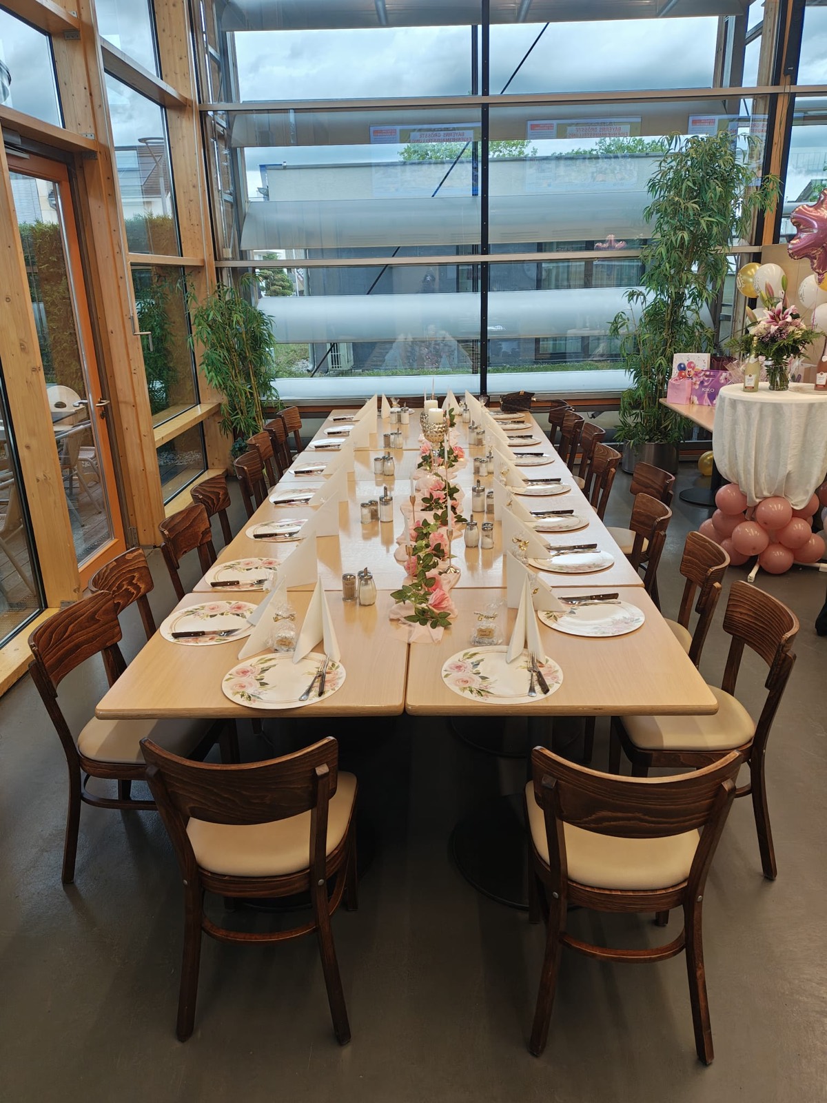 Lange Festtafel mit Rosen-Tischläufer in einer Eventhalle in Poing